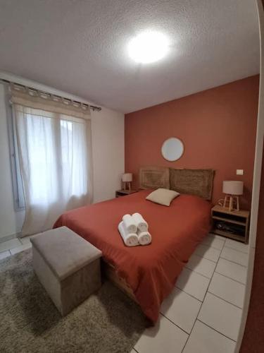 - une chambre avec un lit rouge et 2 serviettes dans l'établissement T2 Hyper centre rénové + parking, proche Comédie, à Montpellier