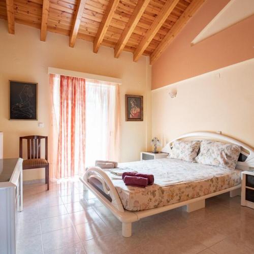 ein Schlafzimmer mit einem großen Bett und einem großen Fenster in der Unterkunft Neromilos Harmony - Roussis Residence in Nerómilos