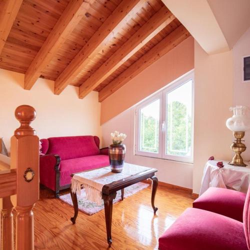 a living room with a red couch and a table at Neromilos Harmony - Roussis Residence in Nerómilos