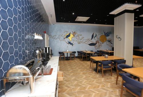 a restaurant with tables and chairs and a mural on the wall at Petra Hotel Trabzon in Trabzon
