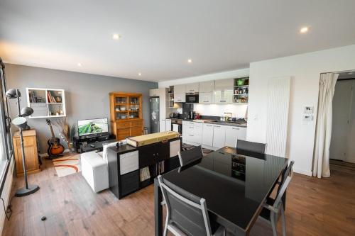 une cuisine avec une table et des chaises dans une pièce dans l'établissement Spacious and bright nest with beautiful terrace, à Bordeaux