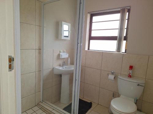 a bathroom with a shower and a toilet and a sink at Rue's place in East London
