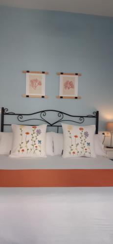 un letto con testiera nera e cuscini bianchi di Acogedor Apartamento Ribeira Sacra a Monforte de Lemos