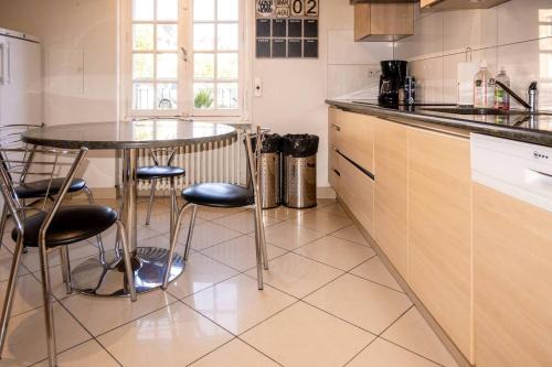 - une cuisine avec une table et des tabourets dans l'établissement La maison de la place, à Lannion