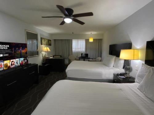 um quarto de hotel com 2 camas e uma ventoinha de tecto em Landmark Suites em Los Mochis