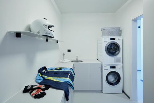 a laundry room with a washer and a washing machine at Racers Lodge Grand Prix - mit Hebebühne und Doppelgarage in Bermel