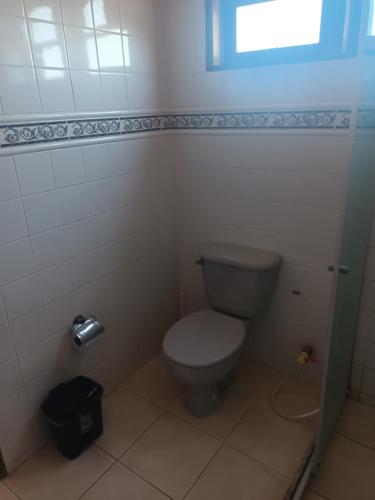 a small bathroom with a toilet and a window at Casa em condomínio Praia Seca in Araruama