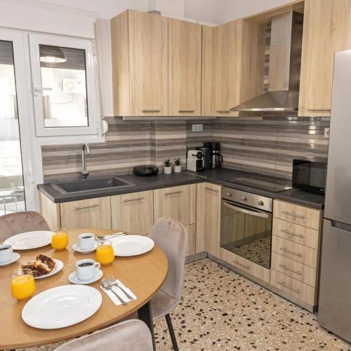 Cozy Apartment in Kallithea في أثينا: مطبخ مع طاولة خشبية عليها طبقين