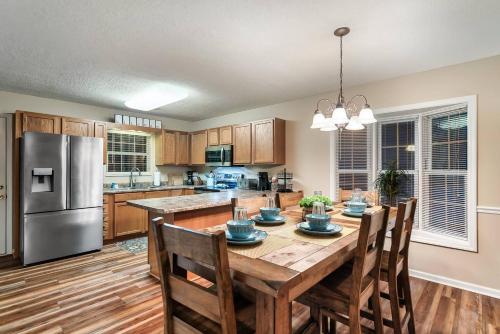 a kitchen with a table with chairs and a refrigerator at 1 Mile to pkwy, Pets, Hot Tub, Creekside, Porch in Pigeon Forge