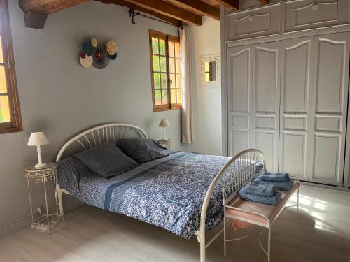 1 dormitorio con 1 cama con edredón azul en La Coraline, en Laubressel