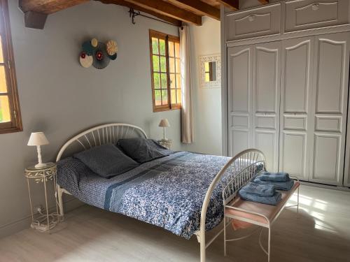 a bedroom with a bed with a blue comforter at La Coraline in Laubressel