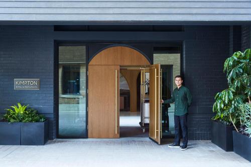 a man standing in the doorway of a building at Kimpton Saint George Hotel by IHG in Toronto