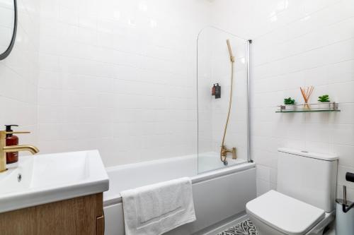 倫敦的住宿－Cosy Apartment in Queens Park，白色的浴室设有水槽和卫生间。