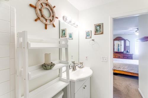 a white bathroom with a sink and a mirror at St Simons Condo with Resort Amenities 1 Mi to Beach in Mallory Park