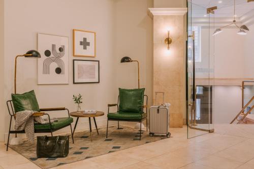 モントリオールにあるSonder Le Victoriaの緑の椅子とテーブル、ガラスドアが備わる客室です。