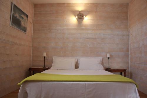 - une chambre avec un lit, 2 tables de nuit et 2 lampes dans l'établissement La Poussada, maisons écologiques avec vue mer, à Lapalme