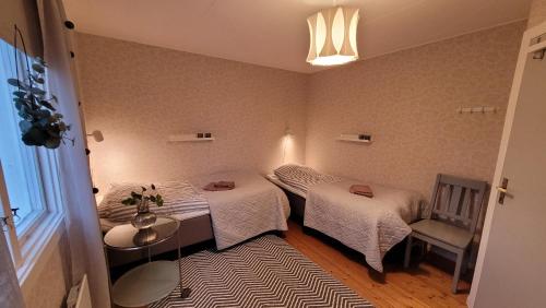 Zimmer mit 2 Betten, einem Tisch und einem Fenster in der Unterkunft Mysig stuga i Svärtinge in Svärtinge