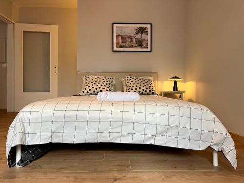 una camera da letto con un grande letto bianco con due cuscini di Suite Leeroy a Lione