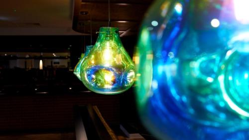 a group of glass vases hanging from a ceiling at Tŷ Newport in Newport
