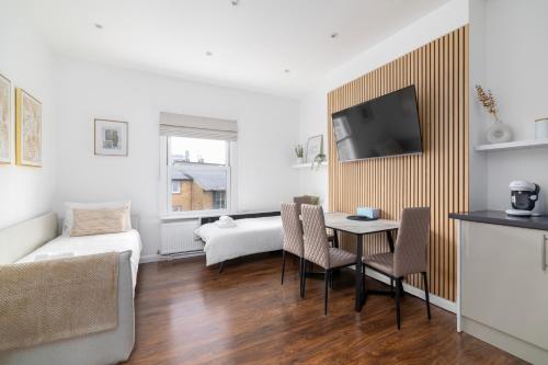倫敦的住宿－Cosy Apartment in Queens Park，客厅配有桌子和沙发