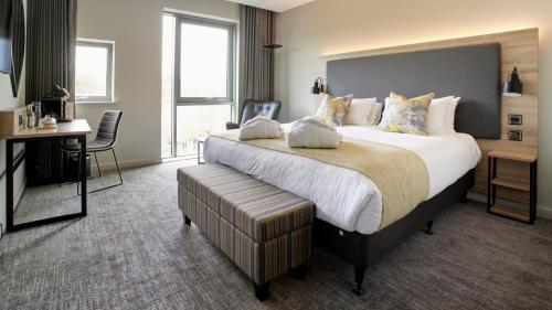 a hotel room with a large bed and a desk at Tŷ Newport in Newport