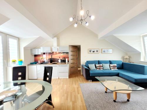 a living room with a blue couch and a table at Apartamenty Cudowna Wyspa in Świnoujście