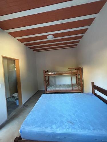 Un dormitorio con una cama azul en una habitación. en Sítio Pequeno Sonho, en Jaboticatubas