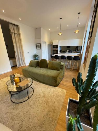 sala de estar con sofá verde y cactus en Appartement Design sur Vauban - Clim et Wifi, en Marsella