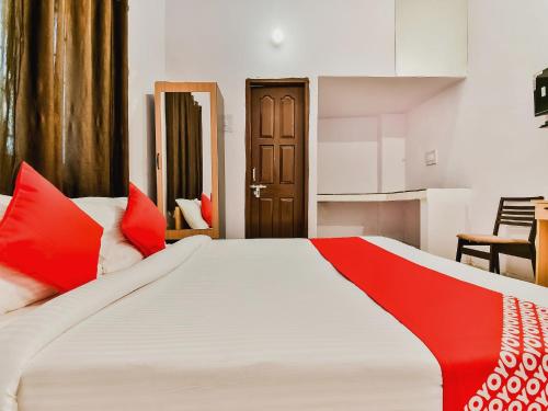 a bedroom with a large bed with red pillows at Super Hotel O Capital Pearl in Patna