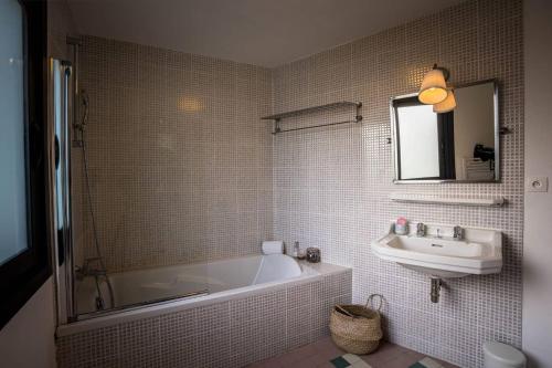 une salle de bain avec une baignoire et un lavabo dans l'établissement le cottage, à Penvénan