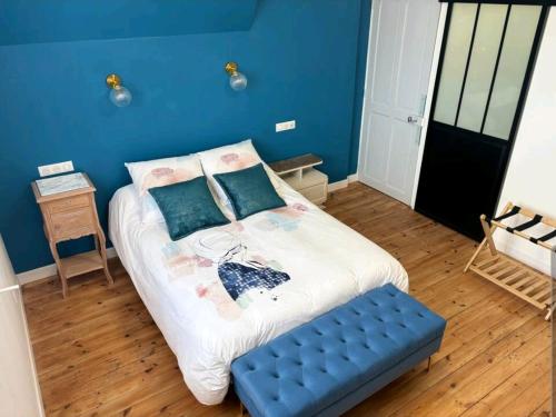 a bedroom with a bed with a blue wall at Villa B in La neuville roy