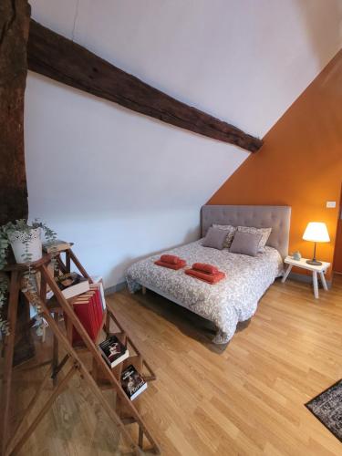 Pocé-sur-CisseにあるLa maison aux irisのベッドと木の床のある寝室