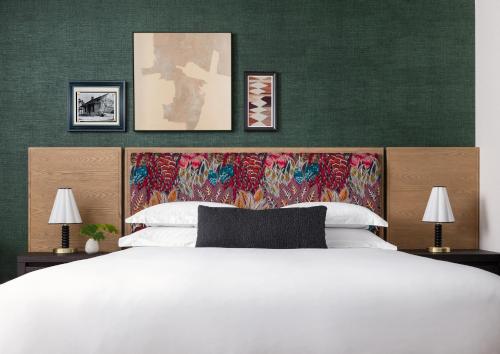 a bedroom with a large white bed and a green wall at Kimpton Santo, an IHG Hotel in San Antonio