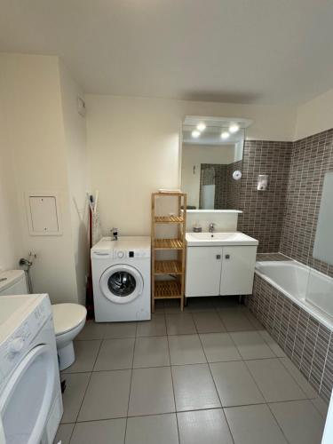 a bathroom with a washing machine and a washer at Dream Apartments in Serris