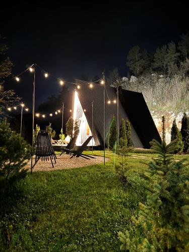 a tent with lights on it in a yard at night at Loon Moon Mountain Chalets in Sarajevo