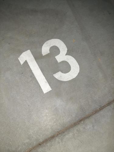 a number thirteen painted on a street at APARTMAN VIAGGIO i PARKING GARAŽA in Sremska Mitrovica