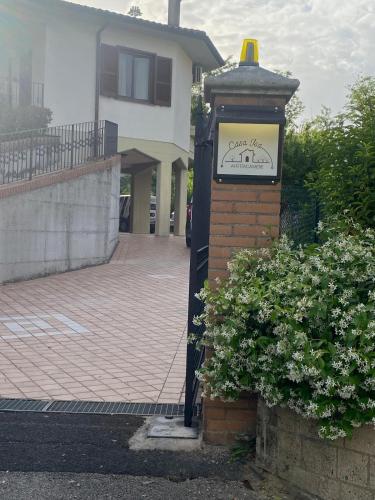a clock on a brick pole next to a building at Casa Isa in Narni Scalo