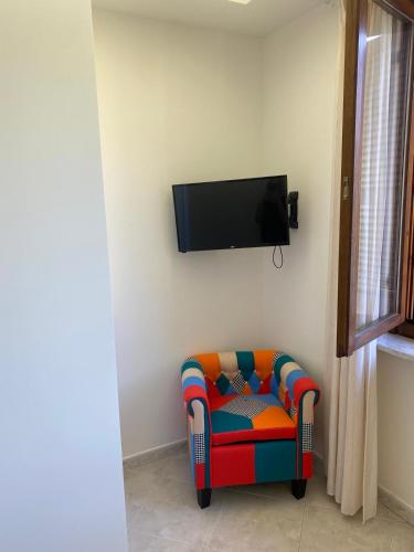 a colorful chair in a room with a tv on the wall at Casa Isa in Narni Scalo