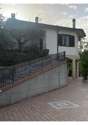 a white house with a fence in front of it at Casa Isa in Narni Scalo