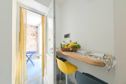 een eetkamer met een tafel en een gele stoel bij Blu Maronti in Ischia