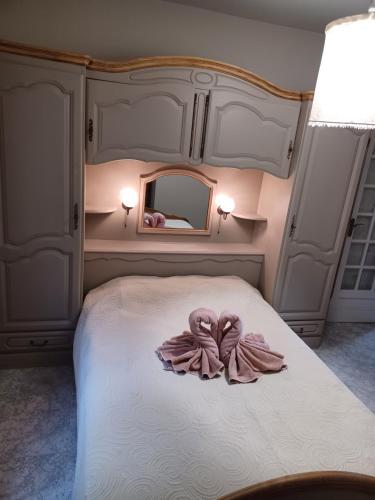 une chambre avec un lit avec des serviettes roses dessus dans l'établissement L'Olivier, à Sainte-Agnès
