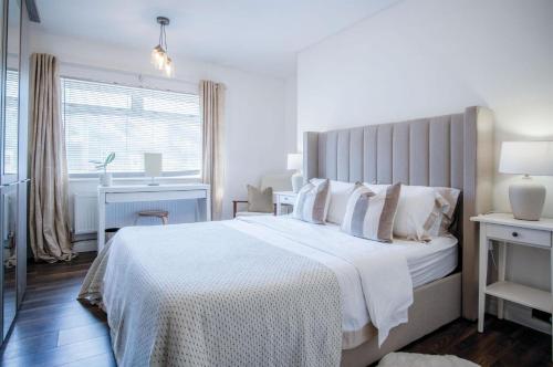 - une chambre blanche avec un grand lit blanc et un bureau dans l'établissement Sunderland Avenue - 2 Bedroom - Pembroke Dock, à Pembroke Dock