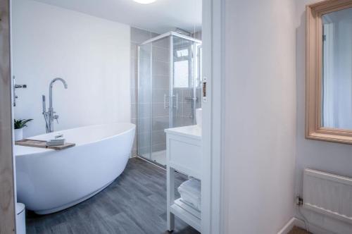 une salle de bain blanche avec une baignoire et une douche dans l'établissement Sunderland Avenue - 2 Bedroom - Pembroke Dock, à Pembroke Dock