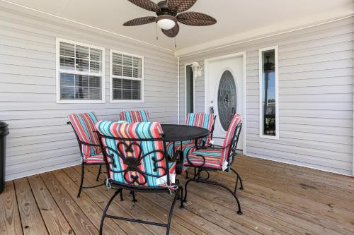 a table and chairs on a porch with a ceiling fan at Salty Breeze by Pristine Property Vacation Rentals in Saint Joe Beach