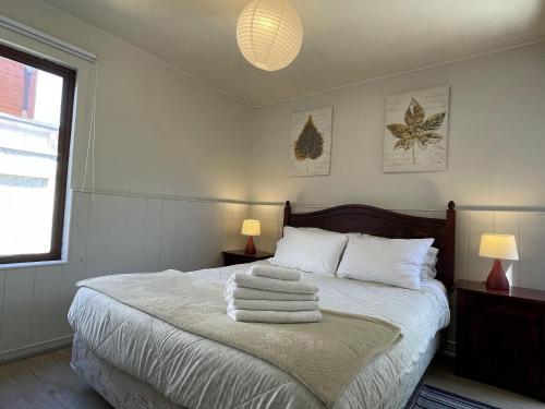 um quarto com uma cama com toalhas em Casa Lomas · Cómoda Casa Lomas San Andrés Empresas/Vacaciones em Concepción