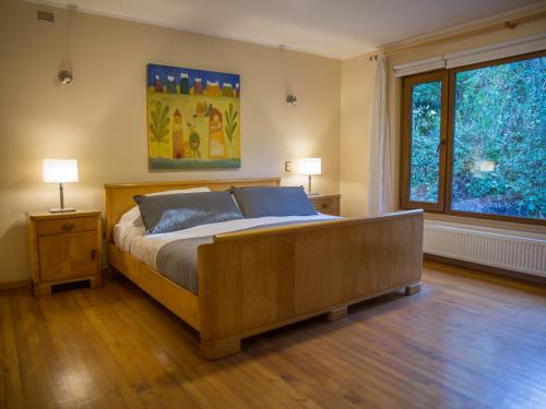 a bedroom with a bed and a large window at Amadeus Hotel Boutique in Frutillar