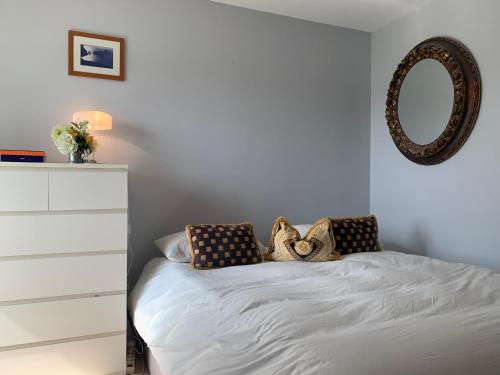 a bedroom with a bed with a dresser and a mirror at Le rondo in Mérignac