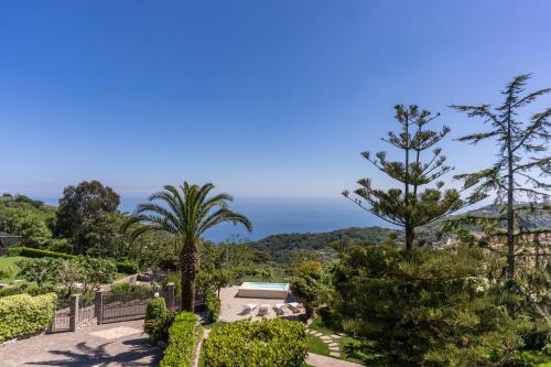 een tuin met bomen en uitzicht op de oceaan bij Villa Solatia in Massa Lubrense