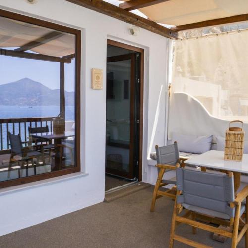 a room with a table and chairs and a balcony at honeymoon klima suite in Klima