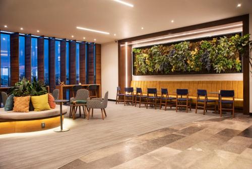 a lobby with a large plant on the wall at voco Guadalajara Neruda by IHG in Guadalajara